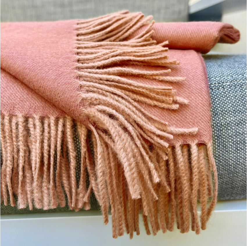 Indulge in this handwoven persimmon alpaca throw, crafted from the finest baby alpaca fiber for exceptional softness, warmth, and timeless luxury.