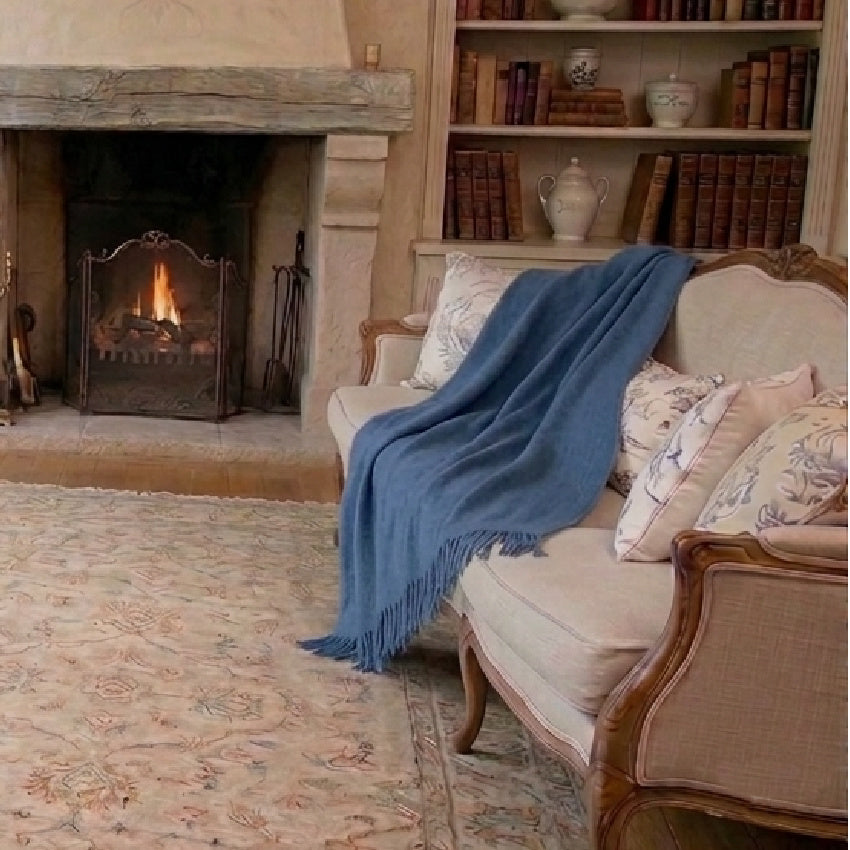 Hand woven blue indigo alpaca wool luxury throw on linen sofa in French country living room