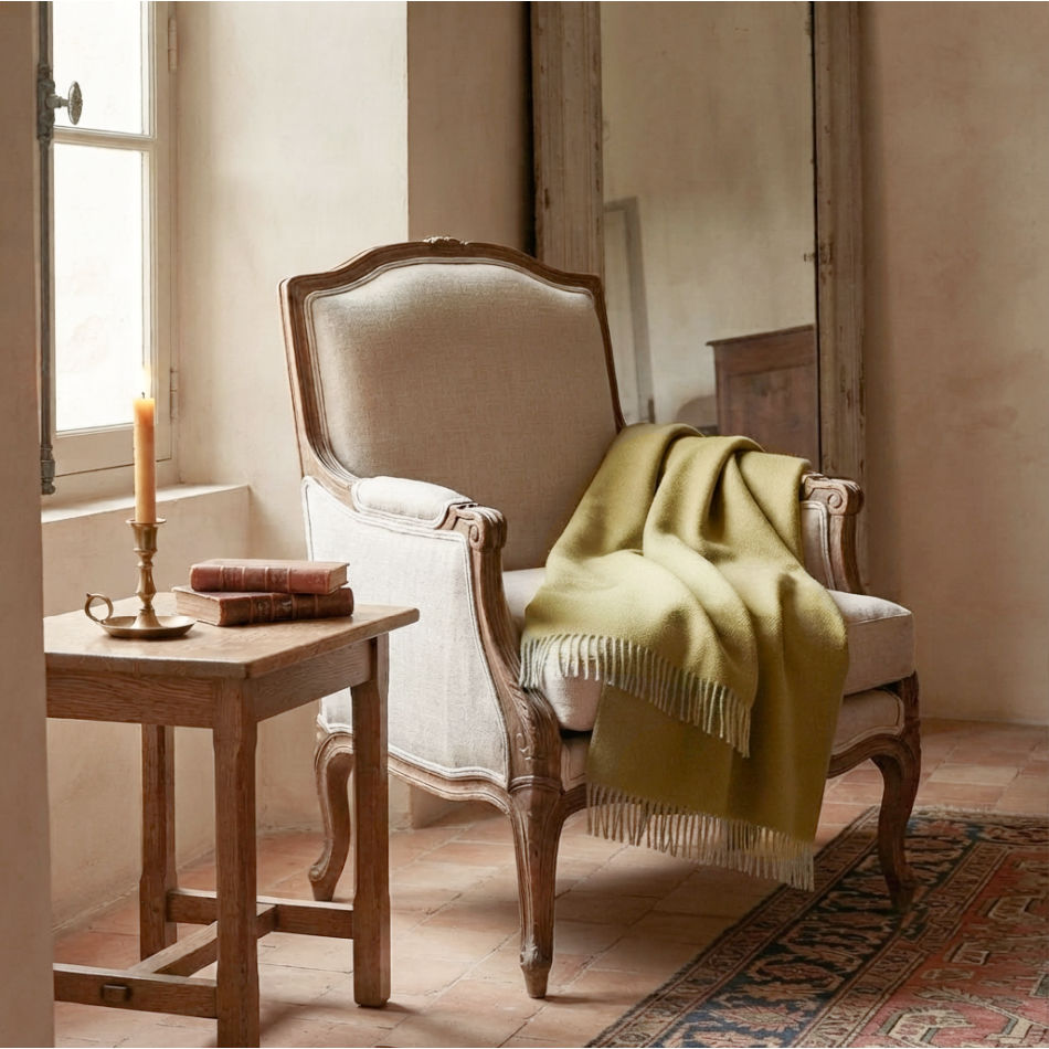 Handwoven baby alpaca throw draped over antique French fauteuil in leaf green