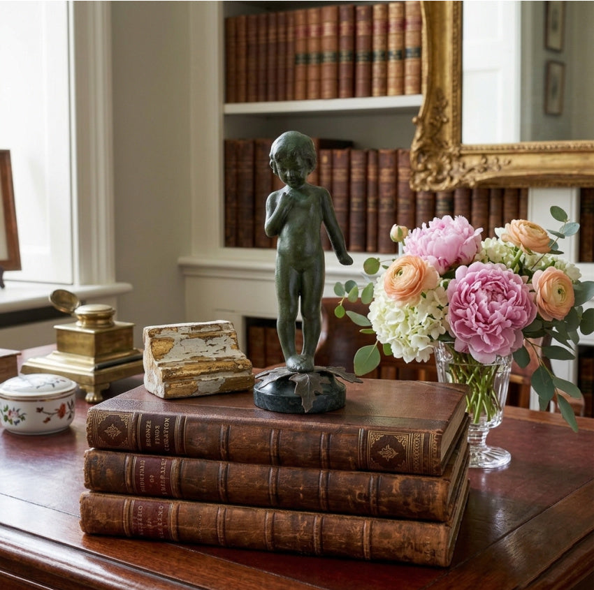 Mid-century cold painted figure of child displayed in collected interior setting library or office