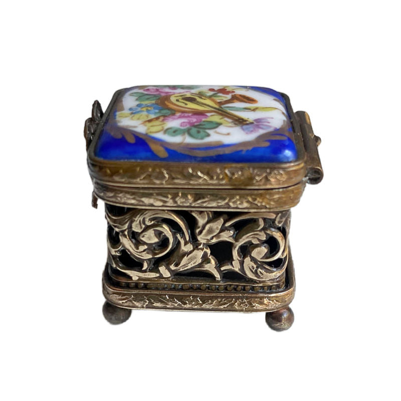 Ornate gilt metal sides of antique Limoges box with blue hand painted lid.