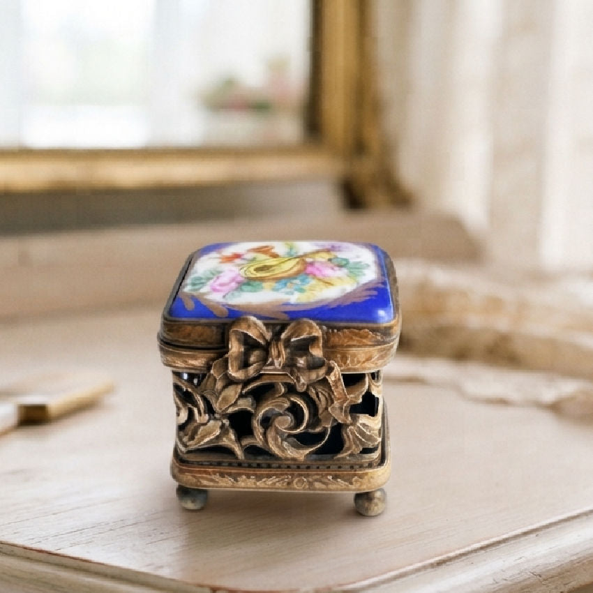 Miniature Gilt Bronze Box with Hand Painted Limoges Top Musical Instruments on top of antqieu french vanity with gold mirror