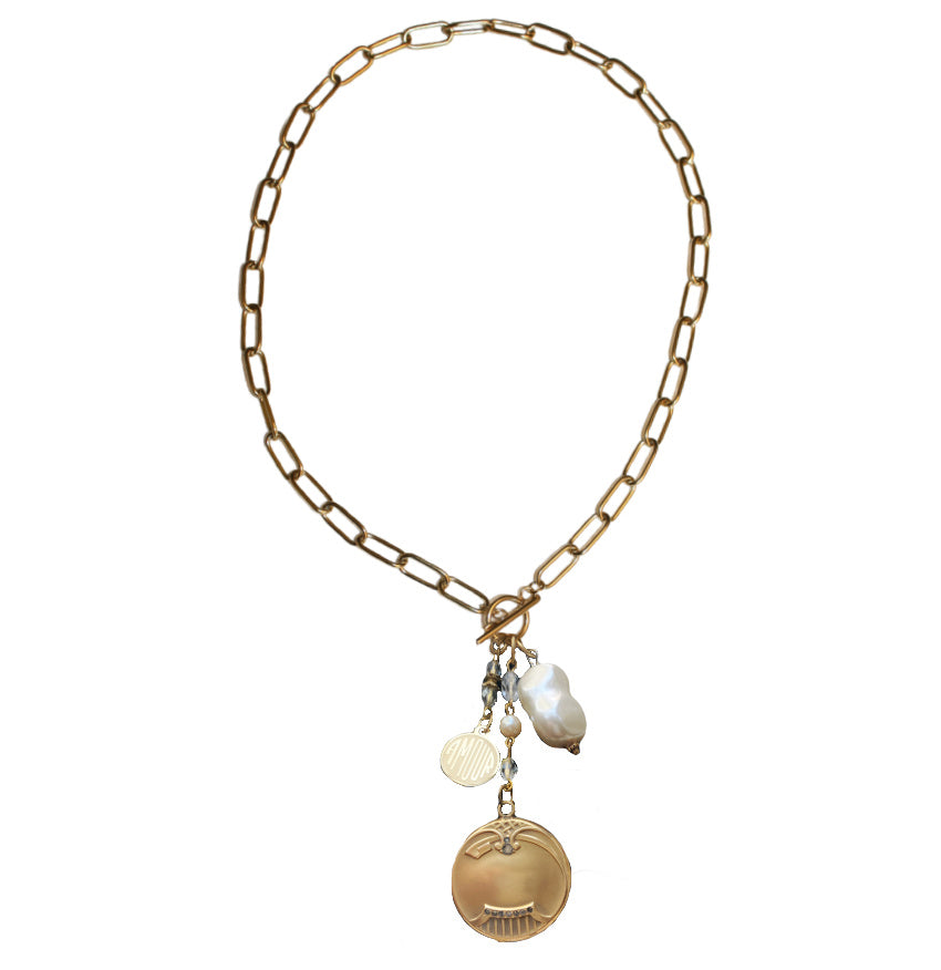 A gold  necklace featuring a gold-filled locket with paste stones, a pearl dangle, and a gold-plated charm, on a chunky paper clip chain.