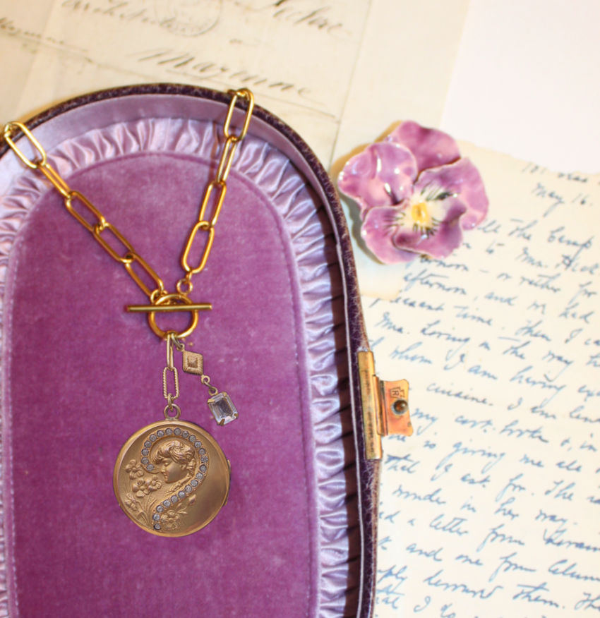 Antique Art Nouveau gold locket necklace featuring a repoussé lady and floral design with paste diamond detail. A romantic objet trouvé treasure.