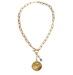 Antique Art Nouveau gold locket necklace featuring a repoussé lady and floral design with paste diamond detail. A romantic objet trouvé treasure.