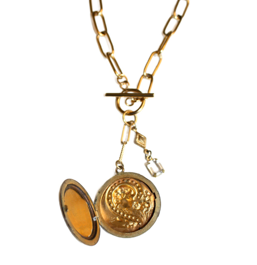 Antique Art Nouveau gold locket necklace featuring a repoussé lady and floral design with paste diamond detail. A romantic objet trouvé treasure.