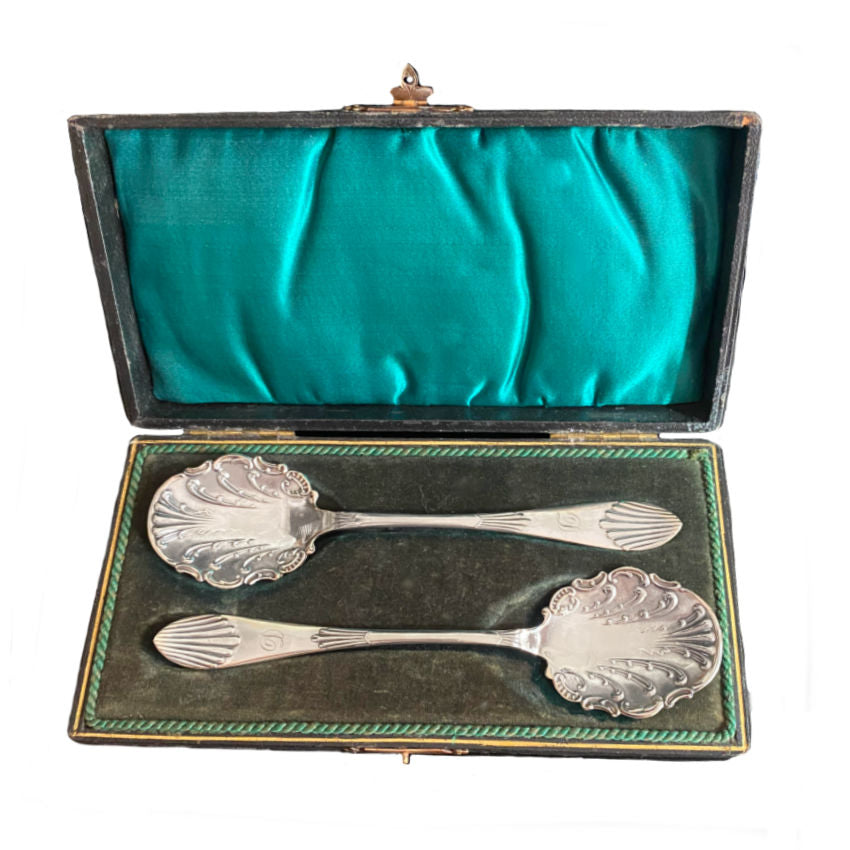 A charming pair of antique silver-plated jam spoons, monogrammed “D” and hand-engraved with rococo shell and leaf motifs. In their original case, increasingly difficult to find and perfect for elegant tables.