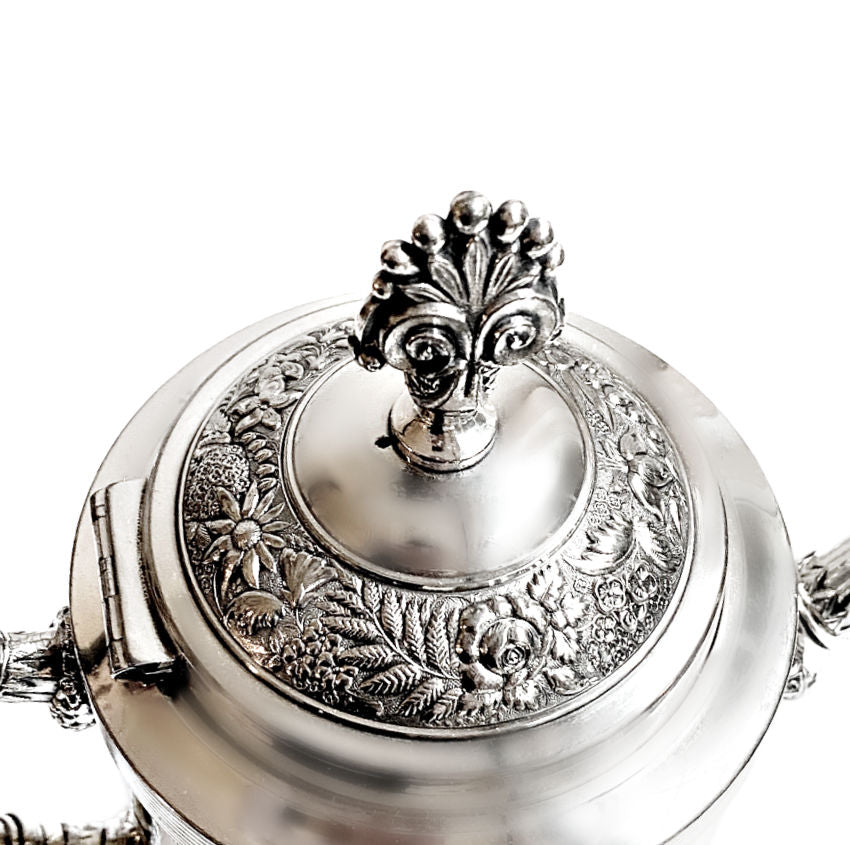 Pair of ornate antique Meriden Britannia silver plated teapots, richly detailed with Victorian repoussé and engraved designs. Elegant display pieces for your home.