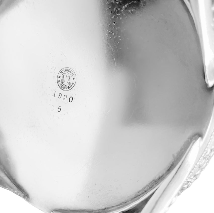 Pair of ornate antique Meriden Britannia silver plated teapots, richly detailed with Victorian repoussé and engraved designs. Elegant display pieces for your home.