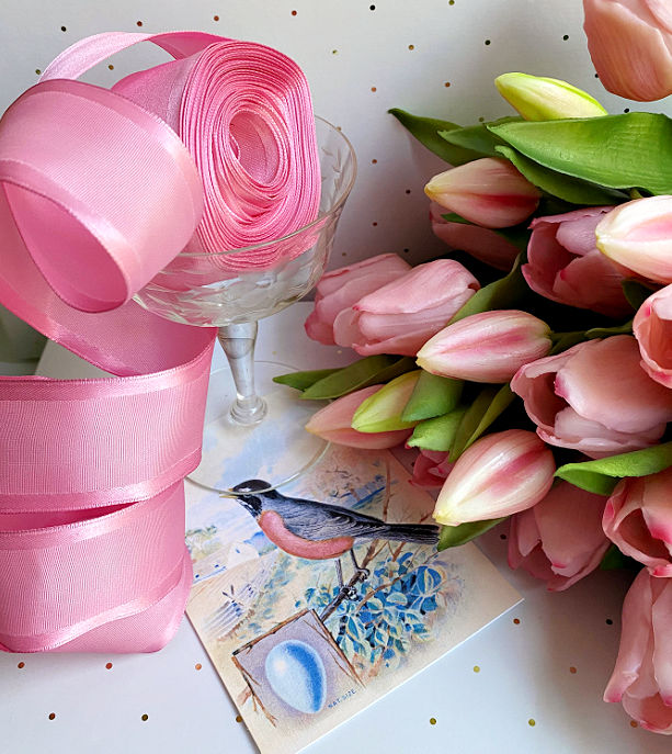 French wired bright pink grosgrain ribbon with satin edges, luxury decorative ribbon for couture wrapping, floral design, and elegant presentation. next to tulips and a spring blue bird card