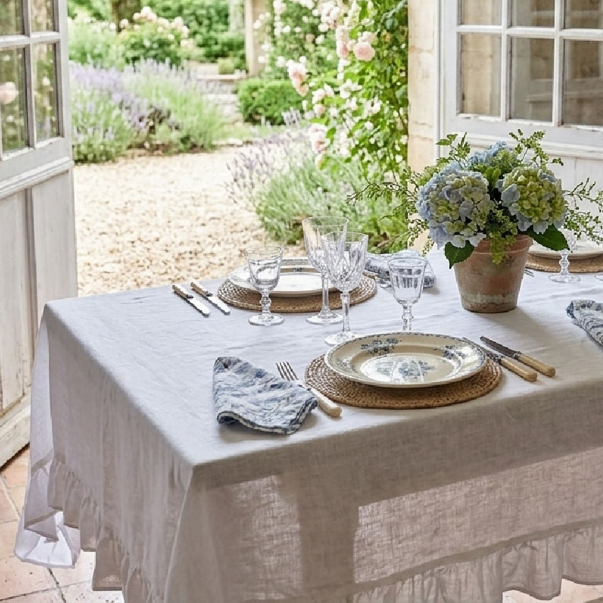 Romantic French country table setting with white organic linen tablecloth