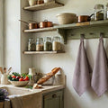 Soft lavender linen drying towel styled near French country kitchen sink in kitchen