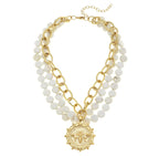 A multi-strand white turquoise necklace with a gold-plated bee pendant, designed by Susan Shaw.