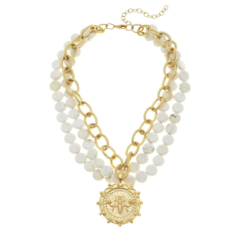 A multi-strand white turquoise necklace with a gold-plated bee pendant, designed by Susan Shaw.