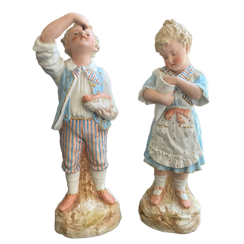 Museum quality Rare matched pair of antique Gebrüder Heubach bisque figurines of a girl and boy enjoying sweets. Exquisite German craftsmanship, circa 1900.