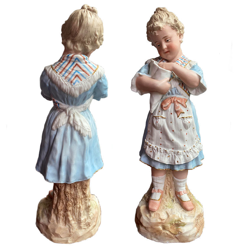 Rare matched pair of antique Gebrüder Heubach bisque figurines of a girl and boy enjoying sweets. Exquisite German craftsmanship, circa 1900.