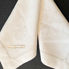Close view of delicate white hand embroidery on antique French linen