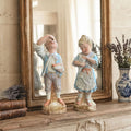 Antique Heubach bisque girl and boy figurals displayed together on a mantel