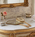 Antique gilt filigree vanity mirror and brush styled on a French dressing table