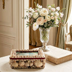 Antique seashell souvenir box displayed among antique curiosities on a French country writing desk