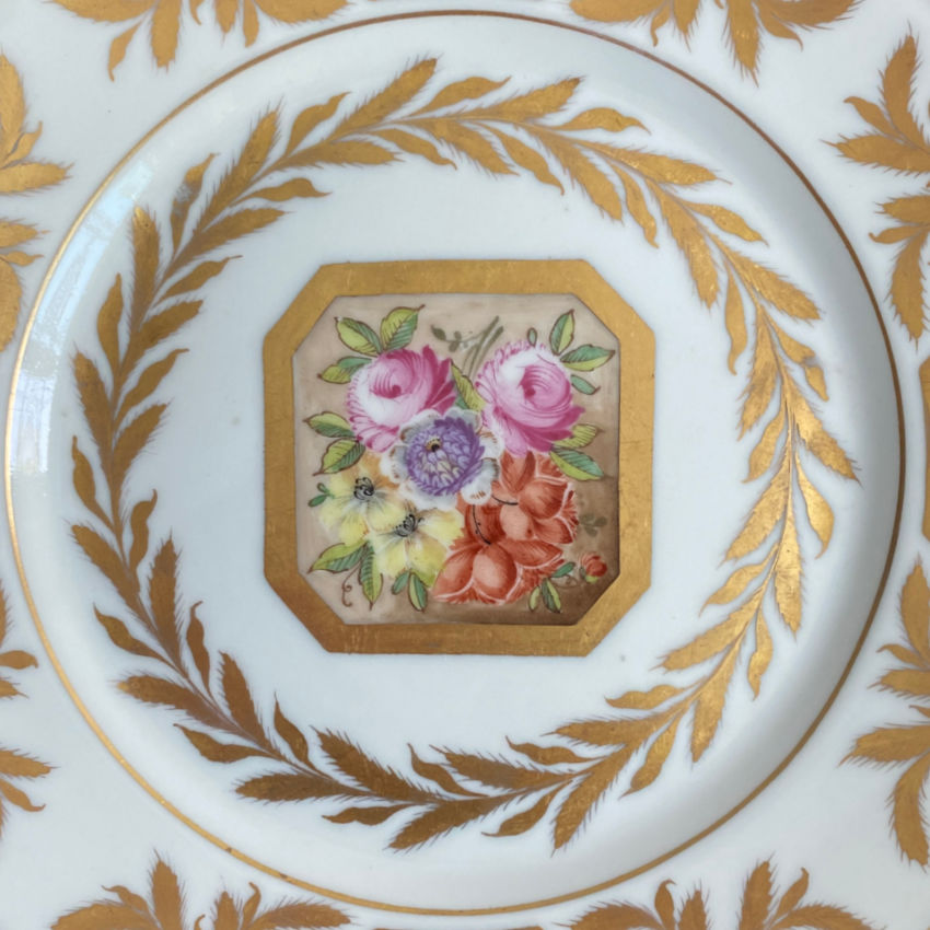 Close up French porcelain plate with rose cartouche and hand painted detail