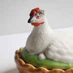 Close-up of hand-painted hen lid on 19th century Staffordshire Hen on Nest Tureen, English pottery showing detailed feathers and eyes.