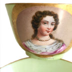 Close up of an antique French Sevres Vieux Paris porcelain tea cup in rare apple green , hand-painted with a delicate female portrait and gilt accents. She is wearing a pink gown and an ermine collar. A charming collectible from a European estate, perfect for antique French porcelain enthusiasts.