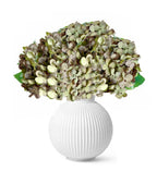Realistic faux hydrangeas in white vase