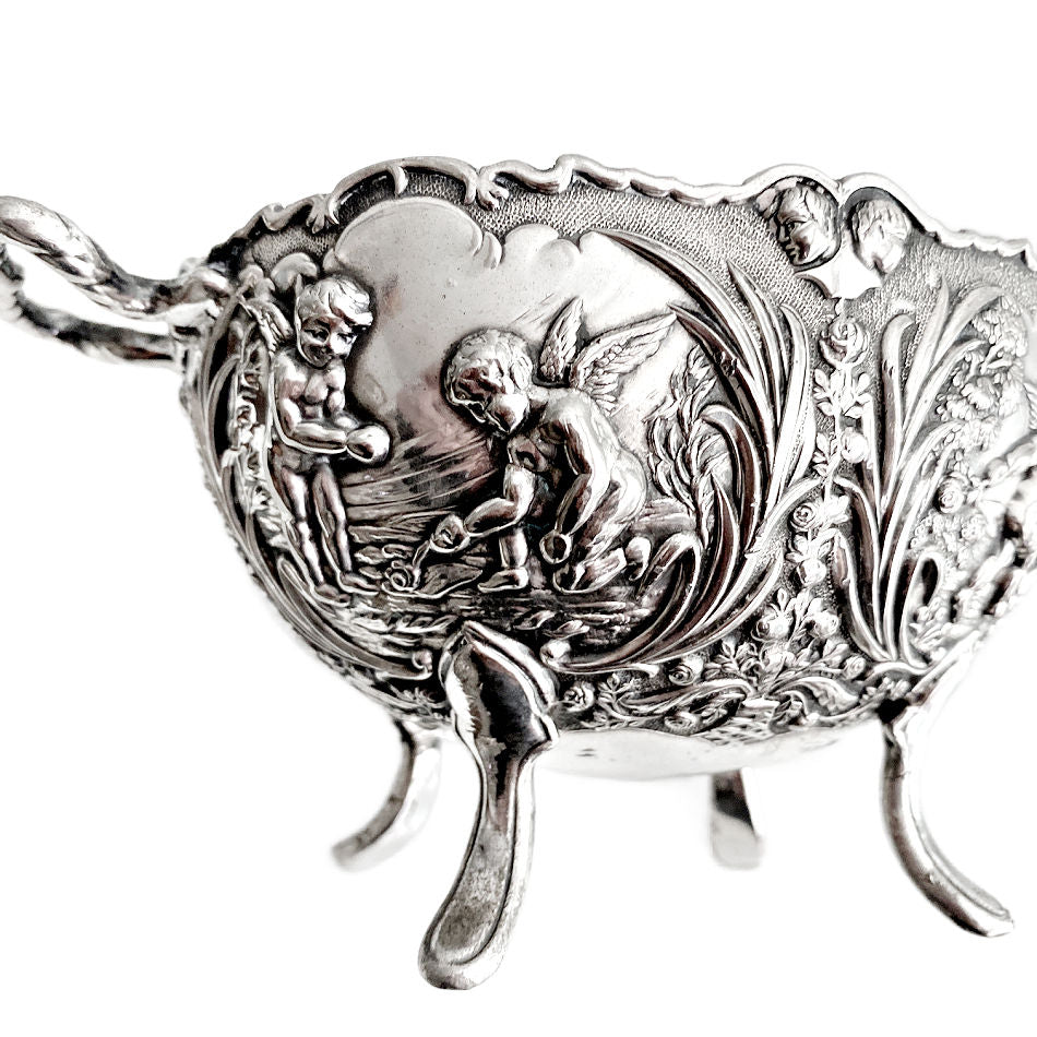 Close-up of cherub and floral relief on vintage silver plated bowl