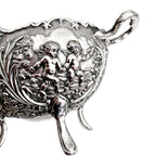 Close-up of cherubs and floral relief on vintage silver plated bowl