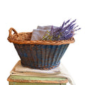 Vintage Dutch faded Delft painted wicker basket styled with antique linens and lavender on an antique chair