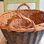 Vintage Dutch basket close-up of integrated handles with wear and faded Delft blue handwoven wicker
