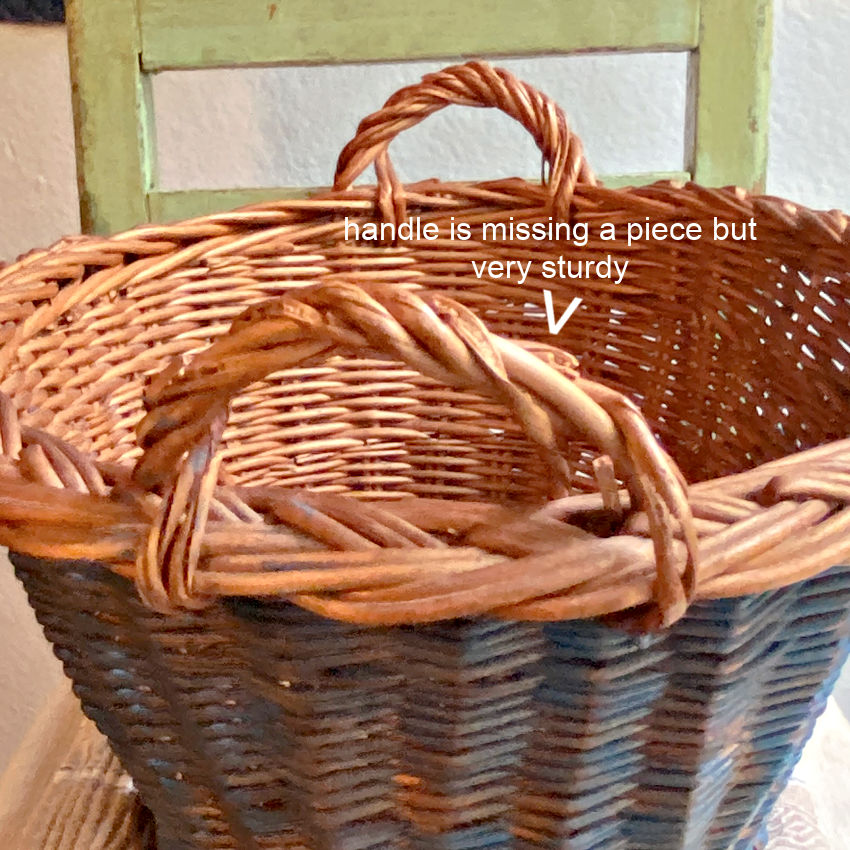 Vintage Dutch basket close-up of integrated handles with wear and faded Delft blue handwoven wicker