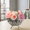 Vintage silver plated cherub and floral footed bowl styled with miniature roses on a cream table in a Paris apartment