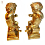 A charming pair of antique Italian Florentine gilt wood cherubs or putti on pedestal bases, beautifully aged with warm patina and red bole showing through the original gilding side views