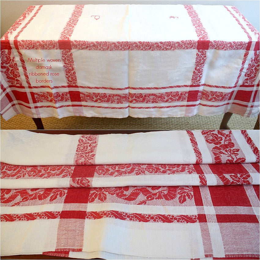 Antique French red and white damask tablecloth with a floral pattern and hand-embroidered monograms in the center.