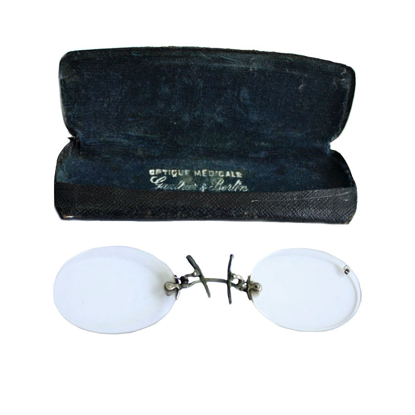 Antique French Pince-Nez eyewear in white glasses with a metal frame, displayed next to their original leather-covered case with Optique Medicale inscription.