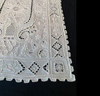 Close detail of exquisite Madeira embroidery on fine white linen