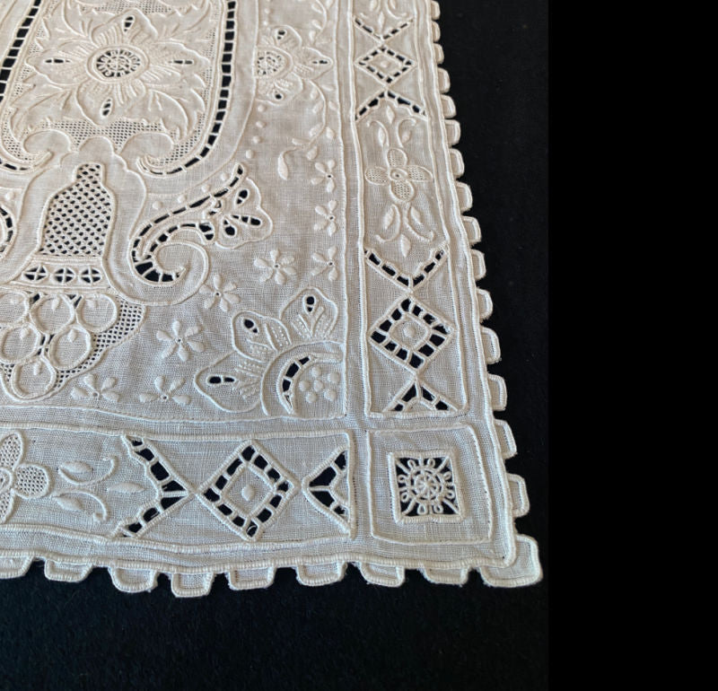 Close detail of exquisite Madeira embroidery on fine white linen