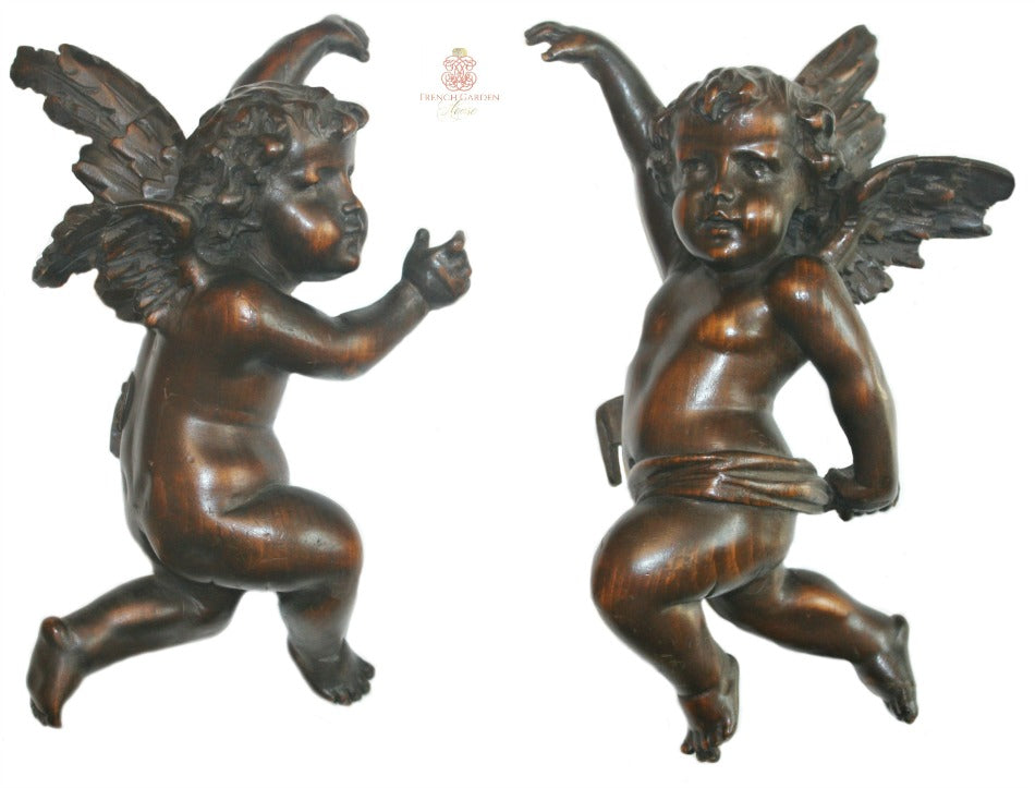 Close detail of hand carved antique wooden putto showing carved feathers and cherubic face