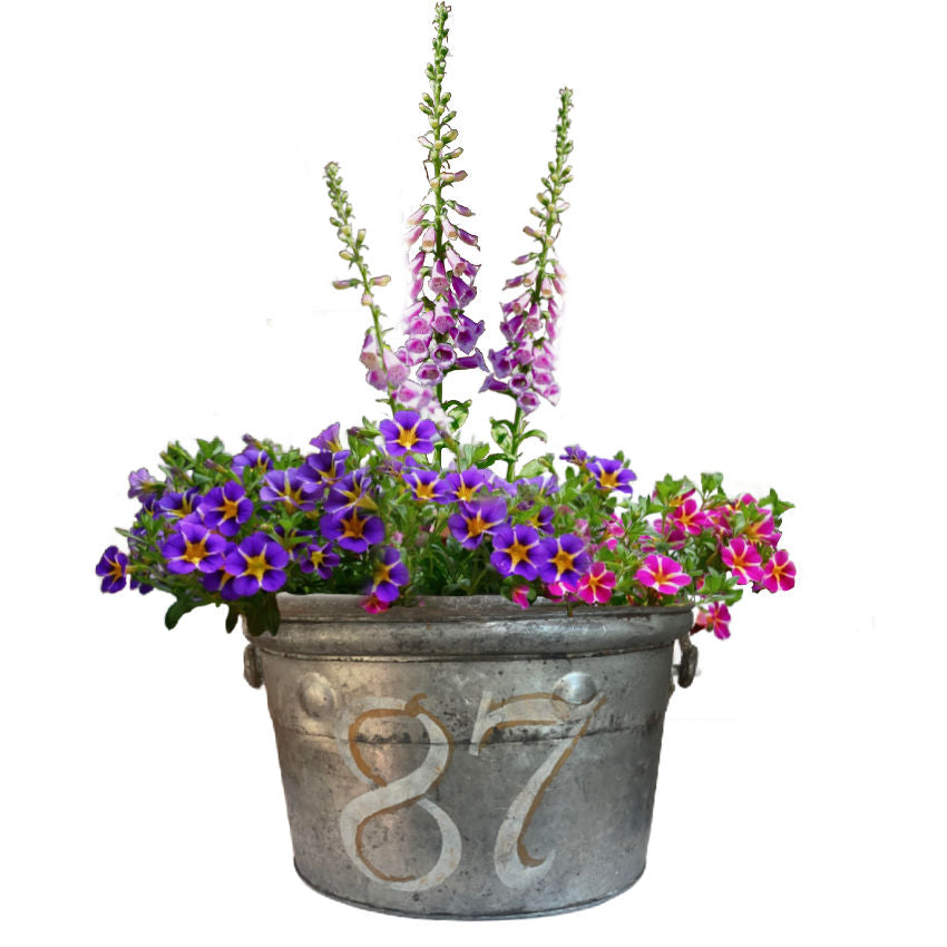 An antique  firefighter's bucket with a patina finish and the number 87 painted on the side.