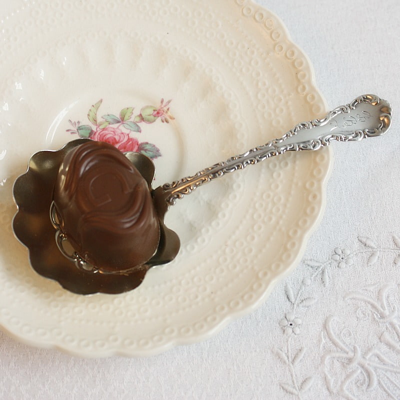 antique sterling silver bonbon spoon on rose plate