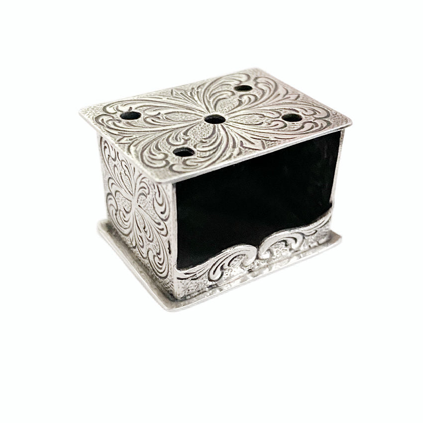 A silver miniature foot stove with ornate detailing, solid silver construction, and openings for 'coals'.