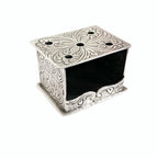 A silver miniature foot stove with ornate detailing, solid silver construction, and openings for 'coals'.