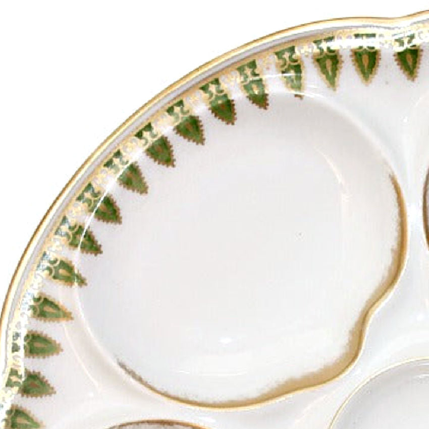 Close-up of hand-painted gold and green design on French oyster plate