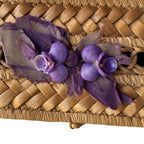 Detail of delicate shell pansies and purple silk bow on a vintage woven box