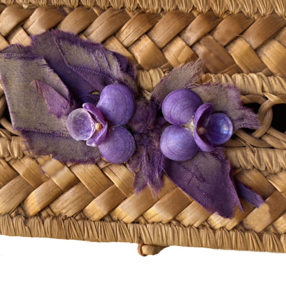 Detail of delicate shell pansies and purple silk bow on a vintage woven box