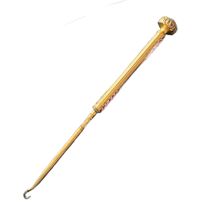 Front view of Antique Apollo Studios gold-plated button hook with delicate pink enamel, early 20th century collectible