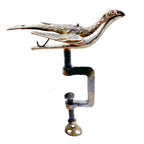 Close-up of antique brass sewing bird with worn hand-painted floral details