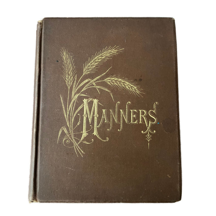 Cover of the 1879 The Manners That Win Victorian Etiquette Book, featuring a title and decorative floral design in gold on a brown background.